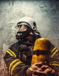 A firefighter in full gear, including a helmet and gas mask, holds a yellow oxygen tank. The background is a textured, metallic gray surface with sparks.